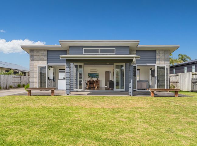 A house with a porch and benches at Sweet As on Aquila - Whitianga Holiday Home Whitianga