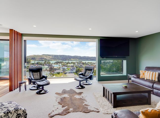 A living room with sofas and a coffee table at Raglan Holiday Home