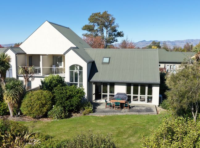 An outdoor dining area with a table and chairs at Vineyard View - Blenheim Holiday Home in Blenheim