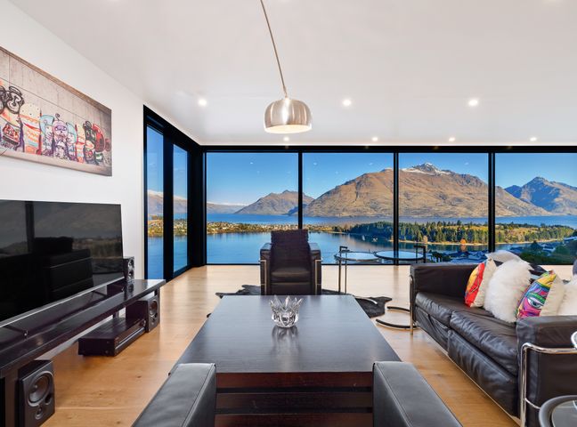 A living room with a television and coffee table at Alpine Haven - Queenstown Villa in Queenstown