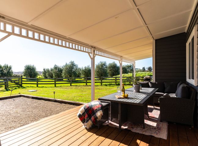 Outdoor seating area with a table and views at Mangawhai Holiday Home in Mangawhai