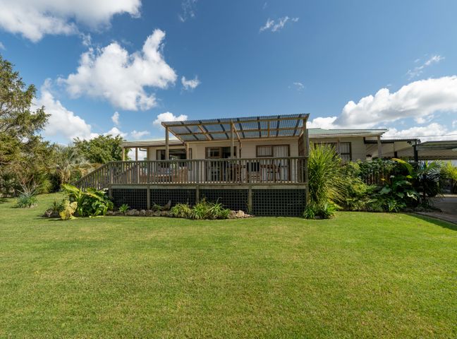 A house with a deck and garden at Calden Cottage - Ngurunguru Holiday Home Ngunguru
