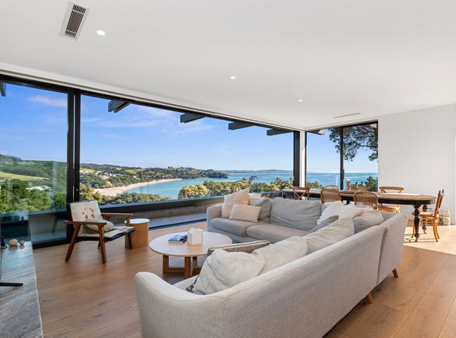 A living room with a sofa, coffee table, and dining area at Langs Beach Holiday Home in Langs Beach