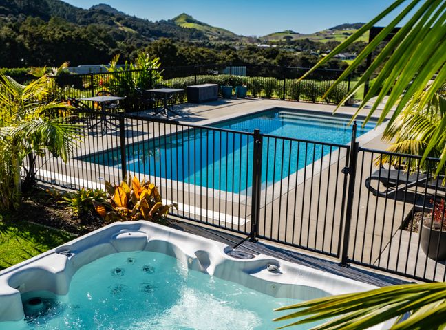 An outdoor area with a pool and hot tub at Mangawhai Holiday Home in Mangawhai