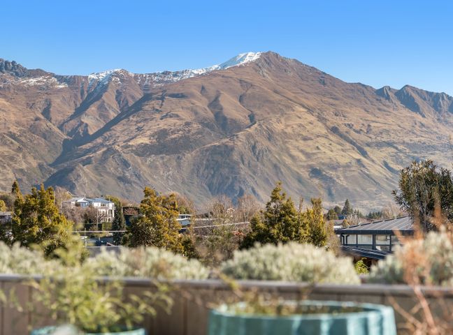 A view of mountains and houses at Peak Perspective - Wanaka Holiday Home in Wanaka