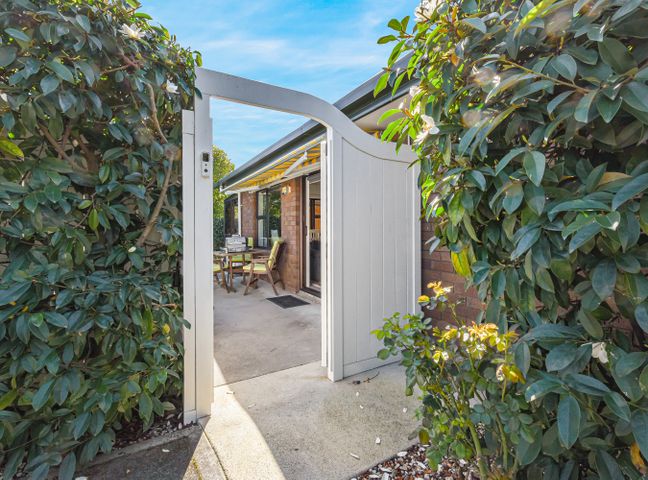 An outdoor patio area with seating and a gate at Magnolia Cottage - Nelson Holiday Homes in Levin