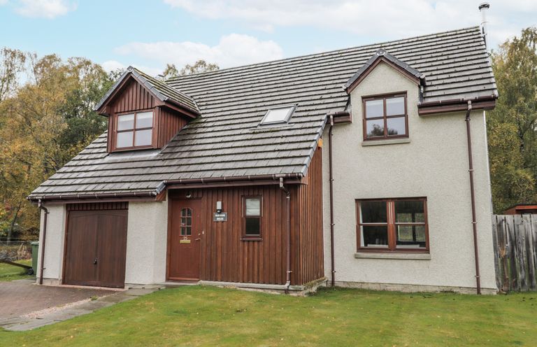 A house with a garage and windows at Burnside House in Aviemore