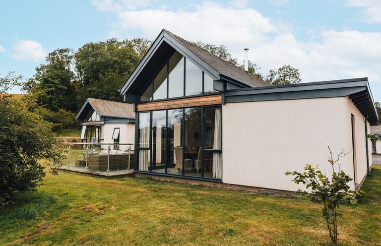 A house with a balcony and glass doors at Cowslip in Bamburgh
