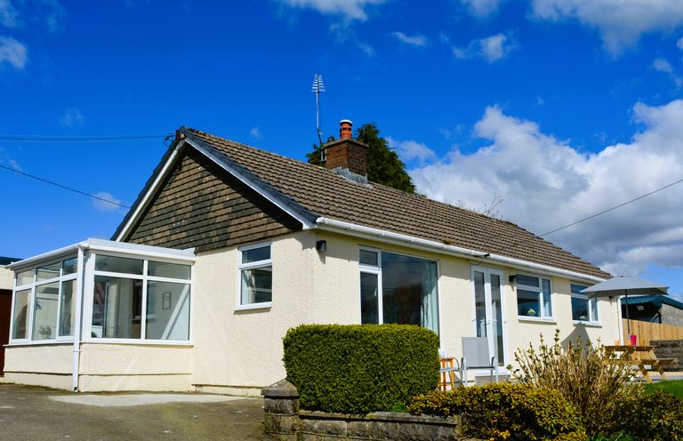 A single-story house with a conservatory and garden furniture at Gwynant in Pontrhydfendigaid