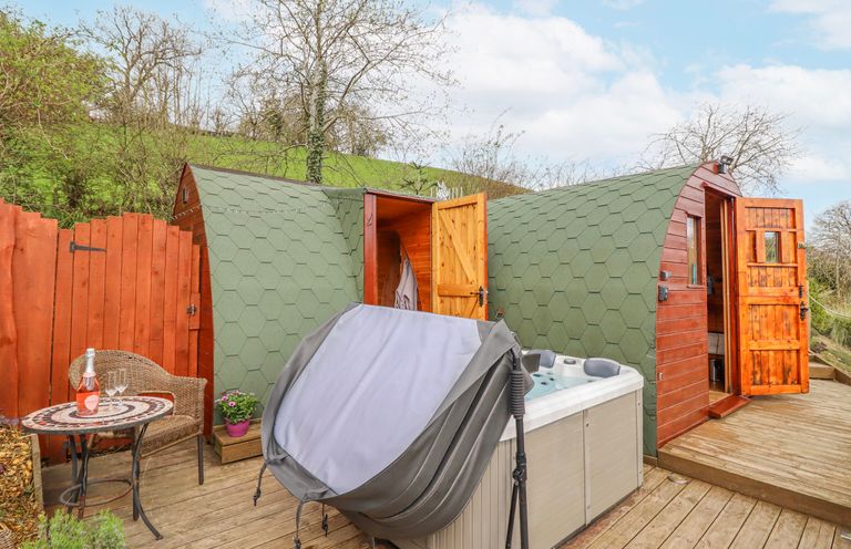 An outdoor area with a hot tub and wooden structures at The Rhiw in Llanfair Caereinion