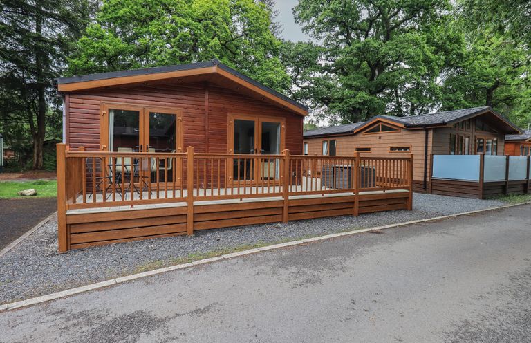 A cabin with a decking and railing at Ridgway Lodge, Calgarth 40, White Cross Bay near Windermere