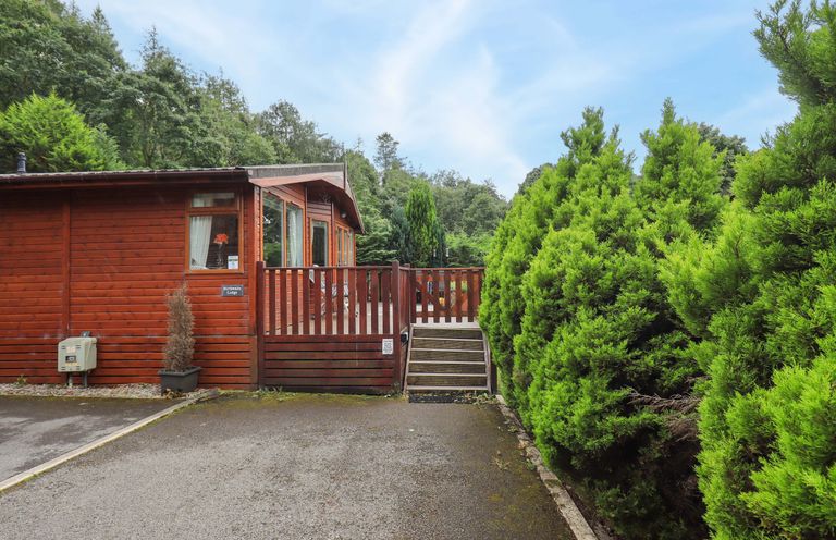 An outdoor view of a lodge with a wooden deck at Birthwaite Lodge, Fellside 6, Limefitt Park near Windermere