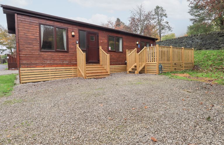 A wooden cabin with steps and a gravel driveway at Robin View Lodge, Beckside 3, Limefitt Park near Windermere