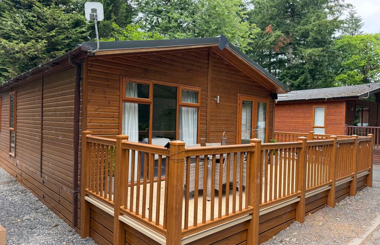 A wooden lodge with a deck and railing at Cherry Tree Lodge Calgarth 37, White Cross Bay near Windermere