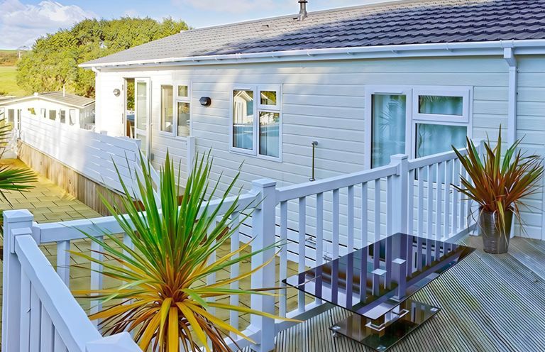 An outdoor deck with a table and plants at The Warren D7 Abersoch