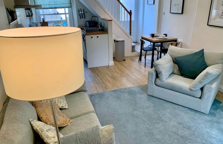 A living room with a sofa and dining table at Bobbin Cottage in Swanage