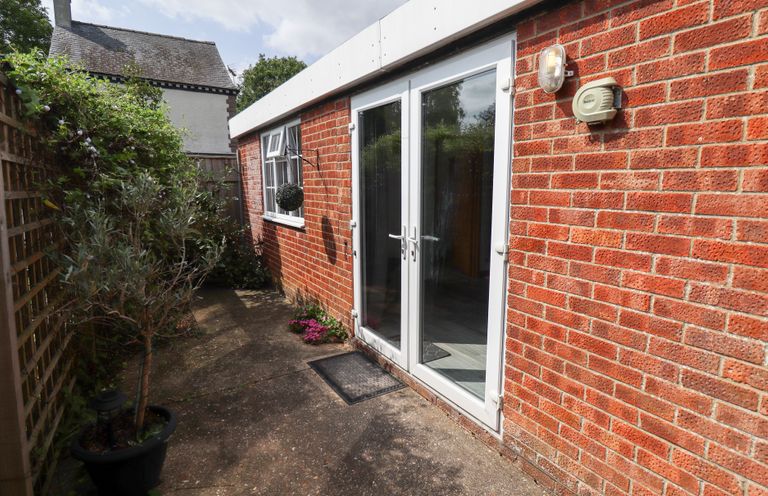An outdoor area with brick walls and double doors at Angel's Retreat in Huttoft