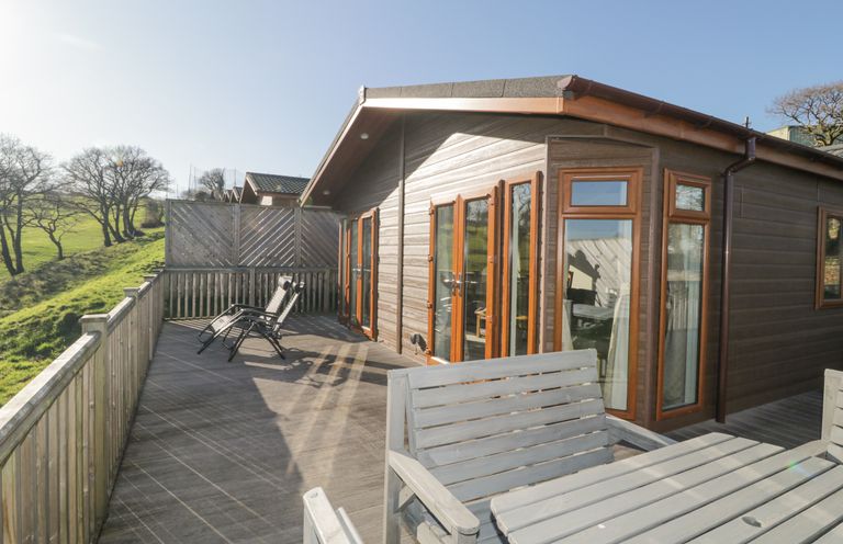 A wooden deck with chairs and shutters on a cabin at Ridge's Retreat No 7 Kigbeare Lodges Ashbury Resort near Fowley Cross Sourton Down and Okehampton