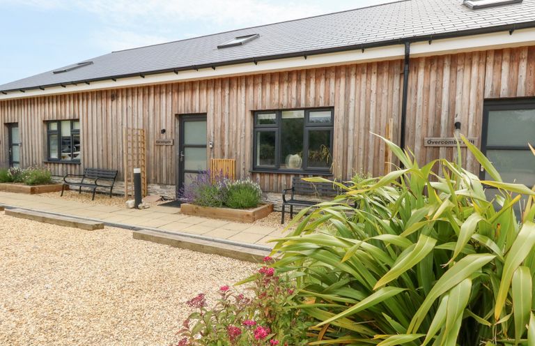 A building exterior with benches and gardens at Corvesgate Nottington near Weymouth