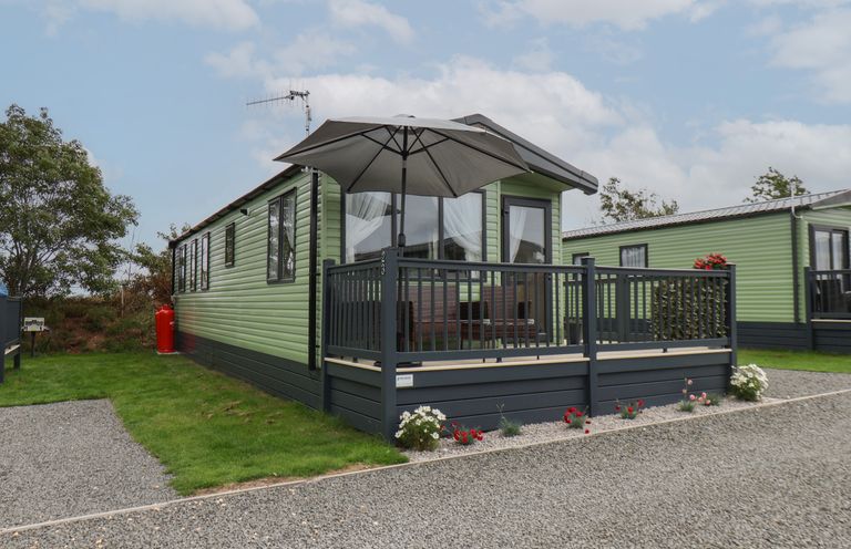 A mobile home with an outdoor deck and umbrella at Jean's Place in East Heslerton near West Heslerton