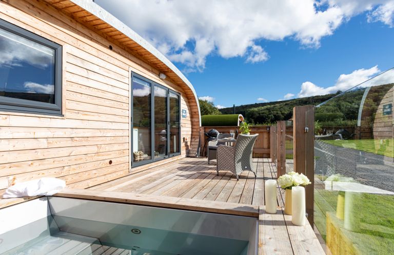 A wooden deck with outdoor seating and a hot tub at High Longlands in Cartmel