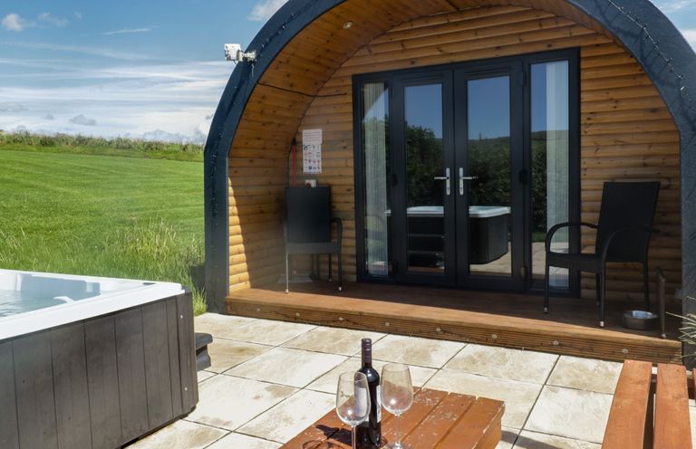 An outdoor area with a hot tub and seating at Holly in Ulverston