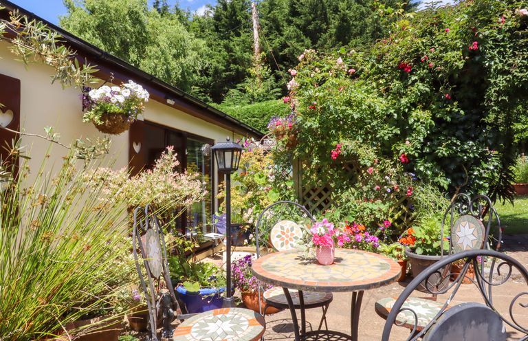 A patio area with a table and chairs at Turnpike Lodge in Brixham