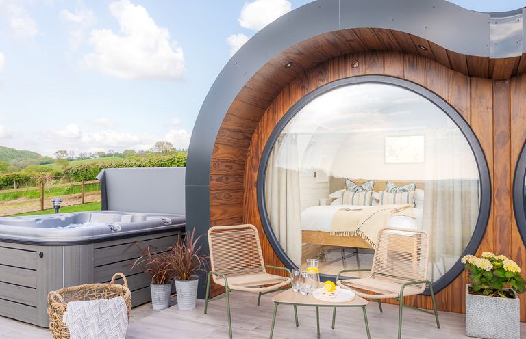 An outdoor area with a hot tub and seating at Ceunant in Llanfihangel-y-Creuddyn near Aberystwyth