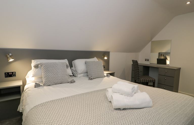 A bedroom with a double bed and folded towels on the bed at Classic Lodge 30 in Dyserth