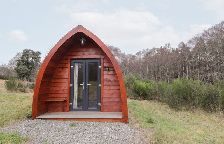 A wooden pod with a door and steps at Pod 2 in Beauly