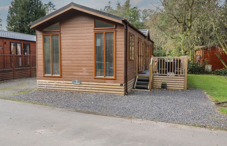 A wooden cabin with large windows and a small staircase leading to a deck at Snuggledown in Troutbeck 5 White Cross Bay near Windermere