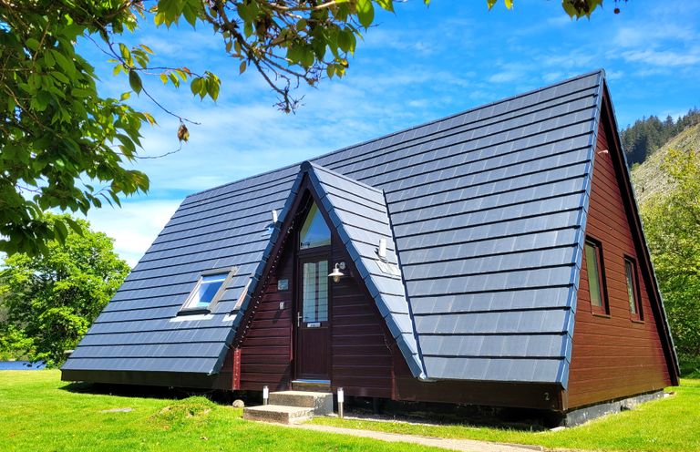 A house with a pitched roof and lawn at Lodge 2 - Inglewood Lodge Spean Bridge