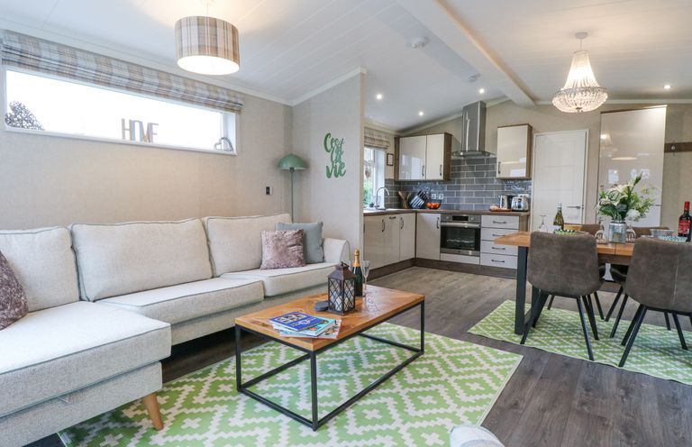 A living room with a sofa and coffee table next to a kitchen and dining table at Wurzburc in Swaffham