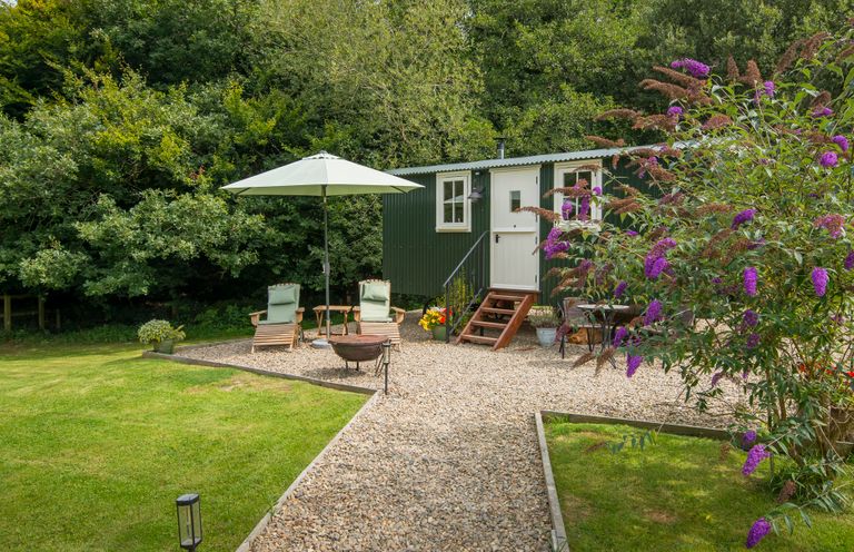 An outdoor area with a green cabin and seating at Collen in Aberaeron