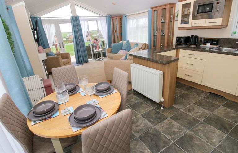 A living room with a dining area and kitchen at Gentle Tide Hasguard Cross near Little Haven