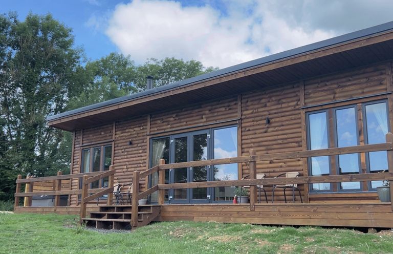 A log cabin with a wooden deck at Foxglove in Higher Wambrook near Chard