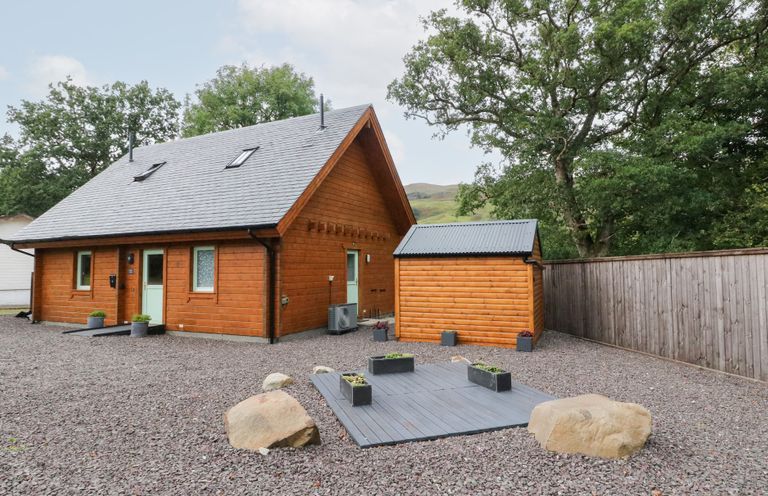 An outdoor view of a wooden house and shed at Bradan Lodge Dalmally