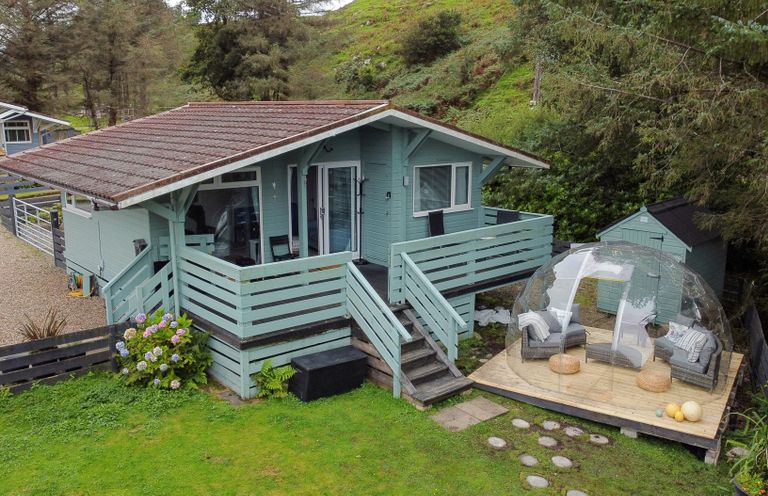 A house with a deck and seating area at Scarba in Balvicar, Isle Of Seil