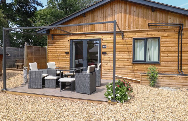 A patio with chairs and a table at Robin's Nest Lodge Snettisham