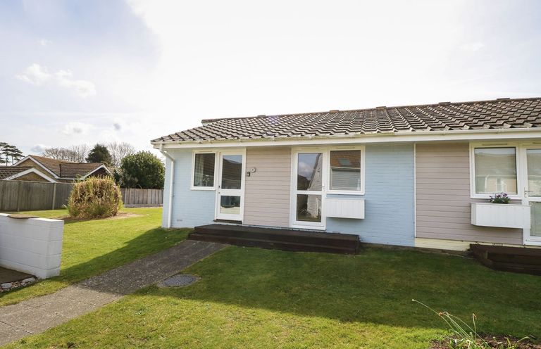 A semi detached bungalow with front doors and windows surrounded by grass at Pierpont D1 Norton near Yarmouth