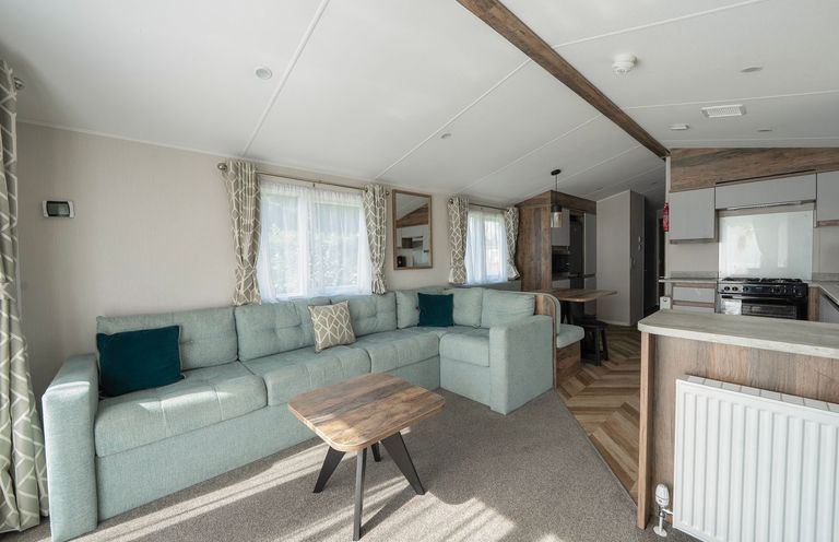 A living room with a sofa and table at Wavecrest - Hayling Island Holiday Park