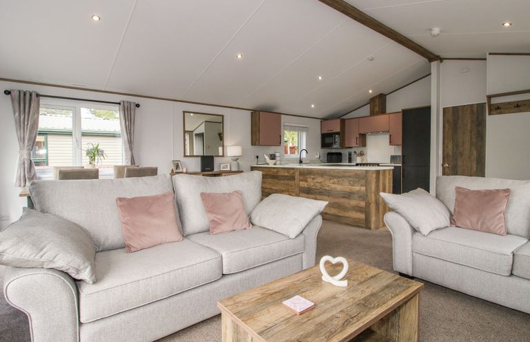A living room with sofas and kitchen area at Peony in Eardisland