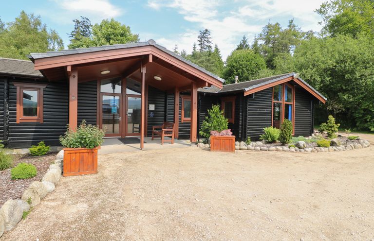 A house entrance with planters and trees at Shore Lodge in Brodick