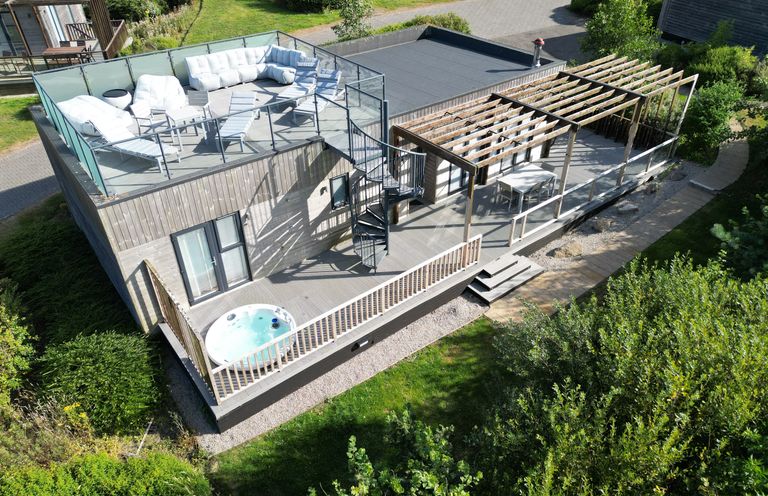 A house with an outdoor seating area and hot tub at The Black Barnacle in Portreath