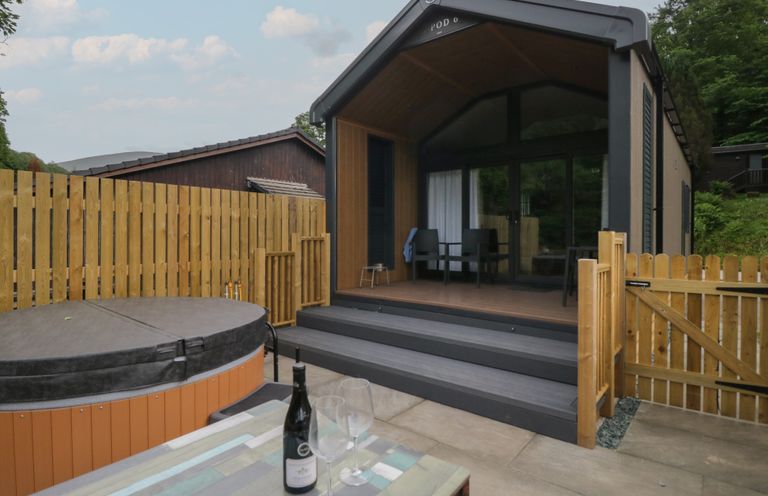 An outdoor area with a hot tub and seating at Woof Luxury Family Pod in Keswick