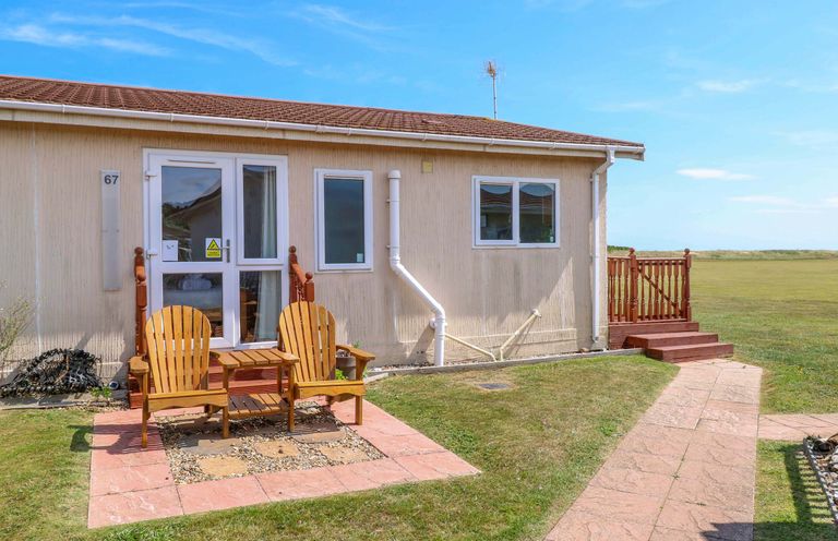 A house with adirondack chairs in front at Boa Vista in Bacton