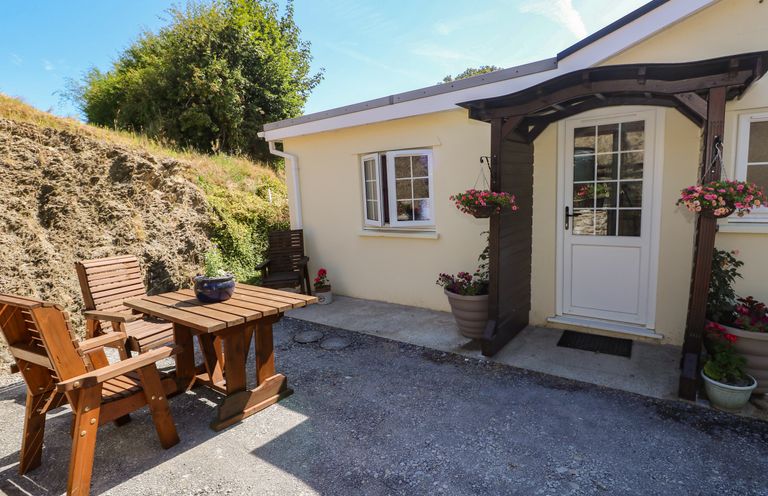 An outdoor seating area with table and chairs at Dolcoed in Manordeilo near Llangadog