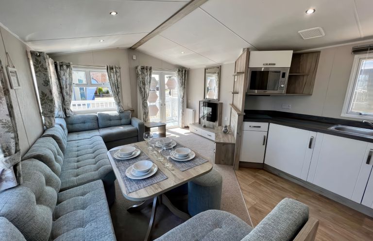 A living room with a sofa and table at Mariner's Meadow - Hayling Island