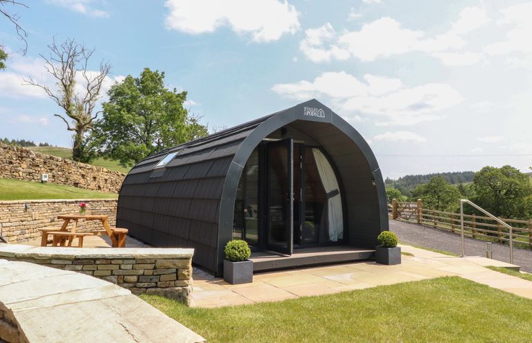 A glamping pod with a table and planter at Barley near Nelson