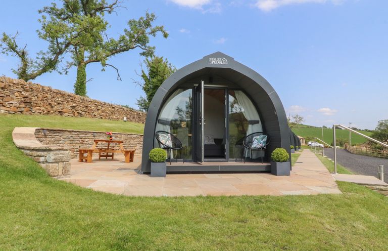 A glamping pod with outdoor seating at Pendle in Nelson